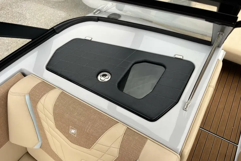  Yacht Photos Pics 2022 Nautique Super Air G23 interior with beige seating and black storage cover.