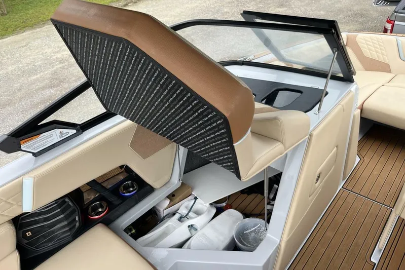  Yacht Photos Pics 2022 Nautique Super Air Nautique G23 interior with tan seating and storage compartments.