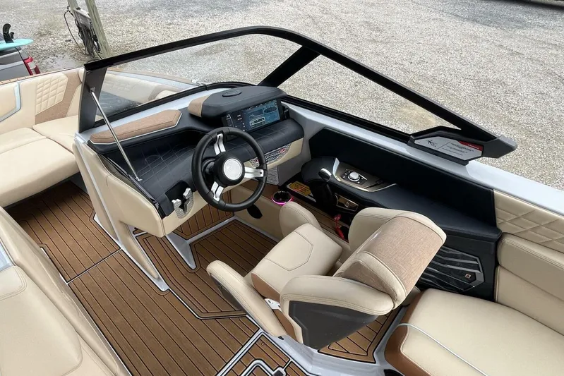  Yacht Photos Pics 2022 Nautique Super Air Nautique G23 boat interior with modern dashboard and beige seating.