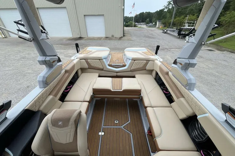  Yacht Photos Pics 2022 Nautique Super Air Nautique G23 interior with beige seating and wood flooring.