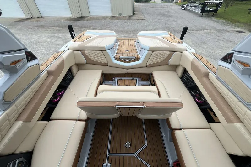  Yacht Photos Pics 2022 Nautique Super Air Nautique G23 interior with beige seating and wood accents.
