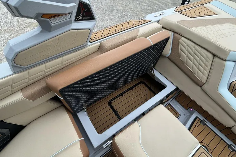  Yacht Photos Pics 2022 Nautique Super Air G23 interior with open storage compartment, showcasing luxury seating.