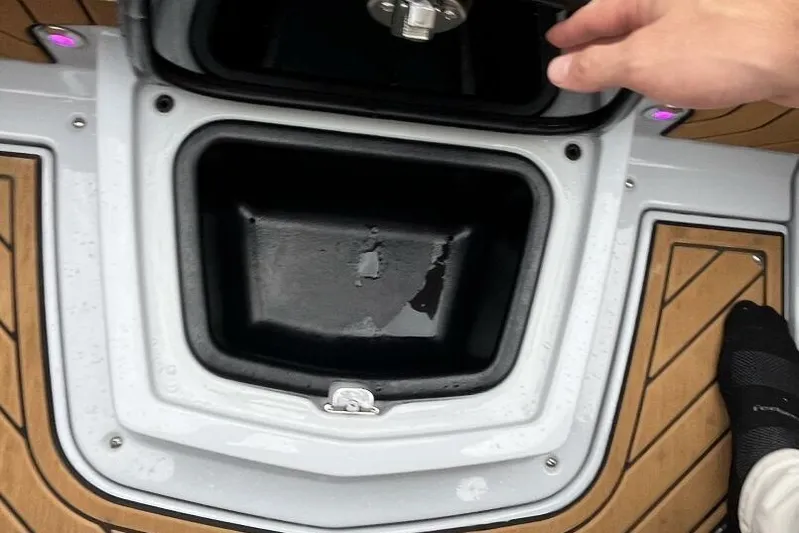  Yacht Photos Pics 2022 Nautique Super Air G23 storage compartment with teak flooring and hand opening lid.