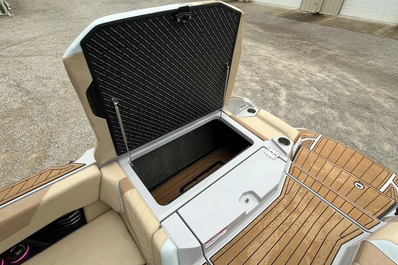  Yacht Photos Pics 2022 Nautique Super Air G23 boat storage compartment with open hatch, featuring teak flooring.