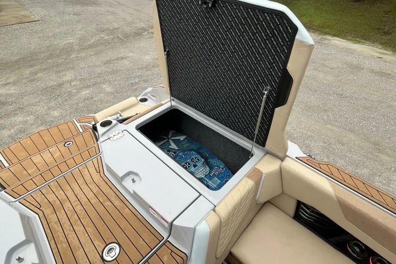  Yacht Photos Pics 2022 Nautique Super Air G23 boat storage compartment with open lid, showcasing interior space.