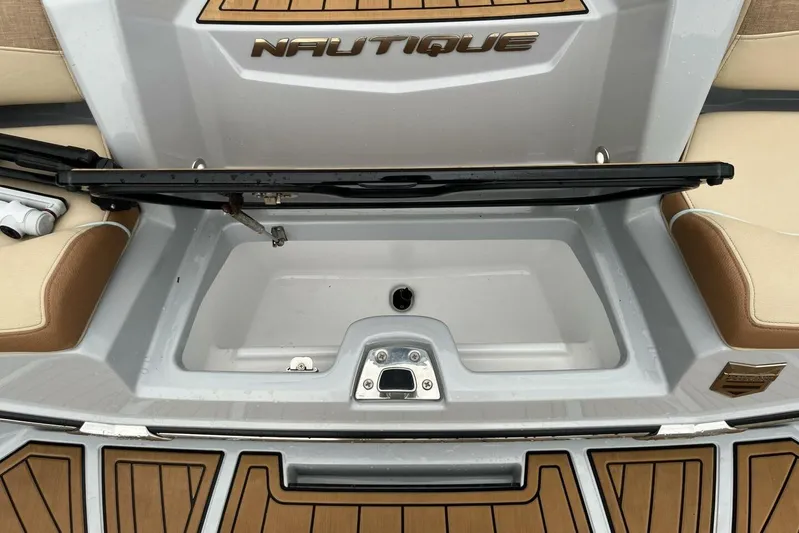  Yacht Photos Pics 2022 Nautique Super Air Nautique G23 storage compartment with teak flooring and beige seating.