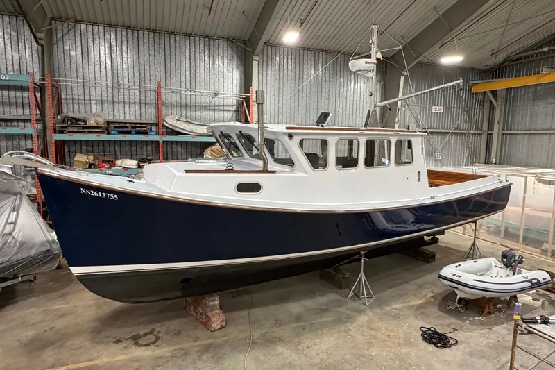 Chad-m Yacht Photos Pics 2022 Covey Island 38 Lobster Yacht in a warehouse, blue and white hull.