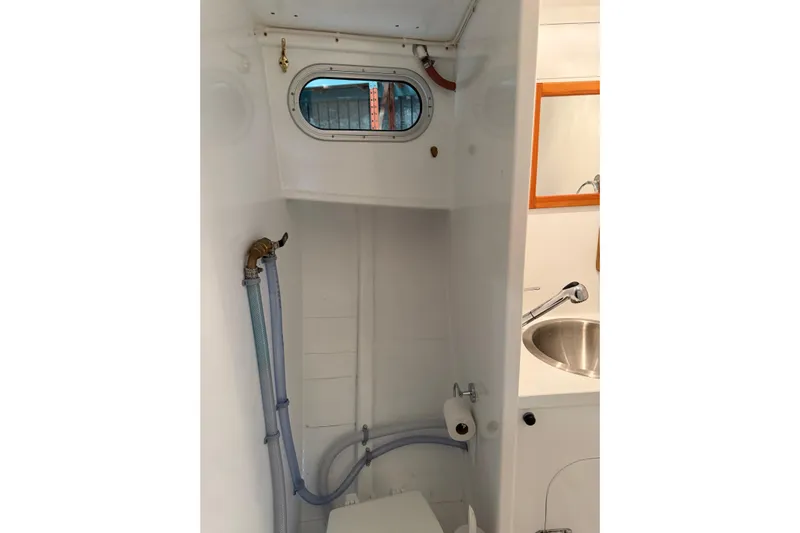 Chad-m Yacht Photos Pics Bathroom interior of 2022 Covey Island 38 Lobster Yacht, featuring sink and porthole window.
