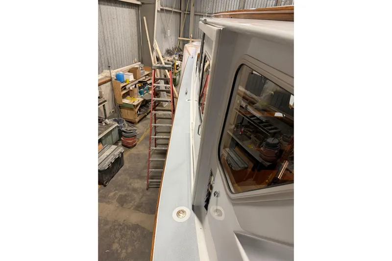 Chad-m Yacht Photos Pics 2022 Covey Island 38 Lobster Yacht in a workshop, side view with ladder and tools.