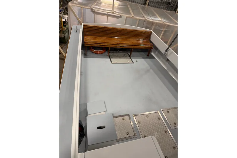 Chad-m Yacht Photos Pics 2022 Covey Island 38 Lobster Yacht deck with wooden bench and storage compartments.