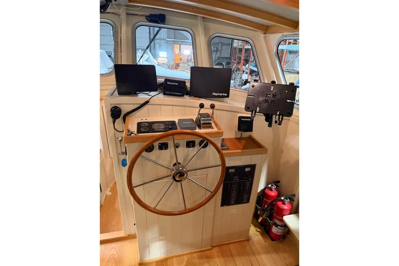 Chad-m Yacht Photos Pics Interior helm of 2022 Covey Island 38 Lobster Yacht with wooden wheel and navigation equipment.