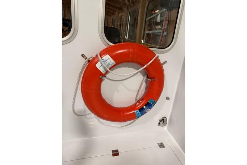 Chad-m Yacht Photos Pics Red lifebuoy on 2022 Covey Island 38 Lobster Yacht, mounted on white wall.