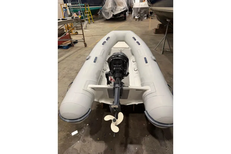 Chad-m Yacht Photos Pics Inflatable boat with outboard motor in a workshop, near a 2022 Covey Island 38 Lobster Yacht.