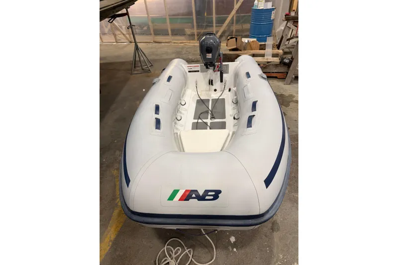 Chad-m Yacht Photos Pics White inflatable boat with motor in a workshop, associated with Covey Island 38 Lobster Yacht 2022.