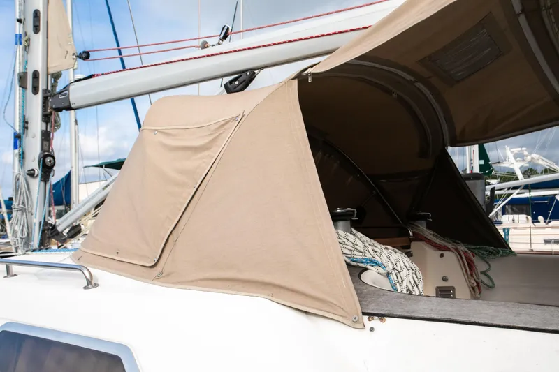 Epoch Yacht Photos Pics Bavaria 47 Ocean sailboat cockpit with beige canvas cover, ropes, and mast visible.