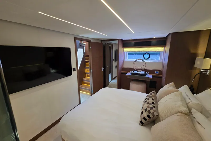  Yacht Photos Pics Luxurious interior of 2022 Prestige X70 yacht bedroom with modern decor and large TV.