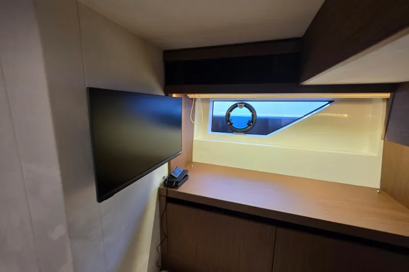  Yacht Photos Pics Modern interior of 2022 Prestige X70 yacht with TV and window view.