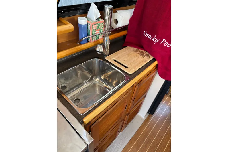  Yacht Photos Pics 2013 Cutwater C-28 boat kitchen sink with wooden cabinets and countertop accessories.
