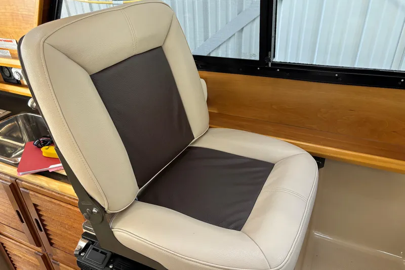  Yacht Photos Pics Captain's chair in 2013 Cutwater C-28 boat interior, near wooden cabinetry and window.