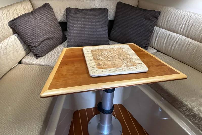  Yacht Photos Pics Interior of 2013 Cutwater C-28 boat with cushioned seating and wooden table.