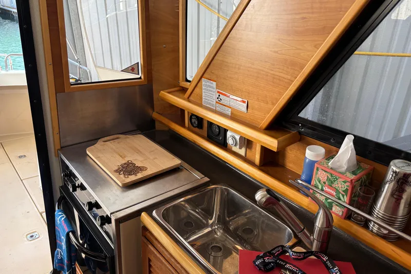 Yacht Photos Pics 2013 Cutwater C-28 boat kitchen with stove, sink, and wooden cutting board.