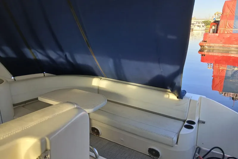  Yacht Photos Pics 2007 Cruisers Yachts 420 Express interior with seating and table, docked by calm water.