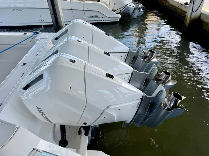  Yacht Photos Pics 2024 Intrepid 407 Nomad FE with triple outboard engines docked in water.