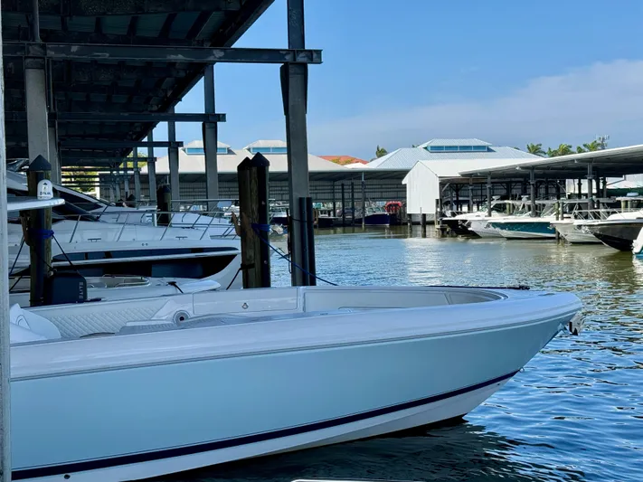  Yacht Photos Pics 2024 Intrepid 407 Nomad FE boat docked in a marina under a clear blue sky.