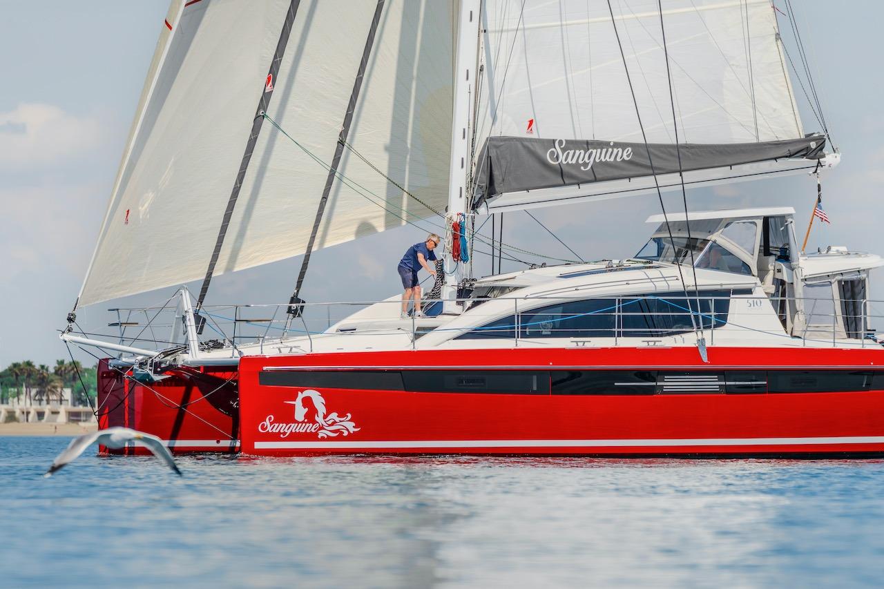 Red Privilege Signature 510 yacht sailing on calm waters, 2025 model.