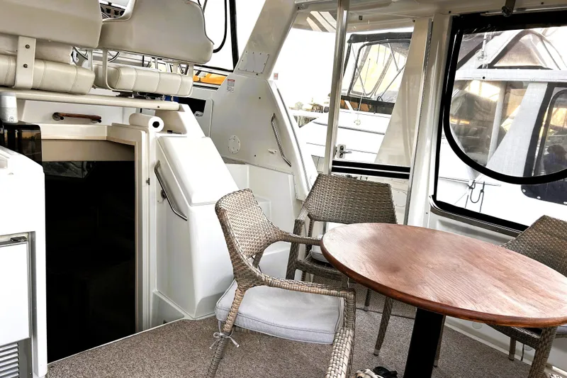  Yacht Photos Pics 2001 Carver 356 Motor Yacht interior with wicker chairs and wooden table.