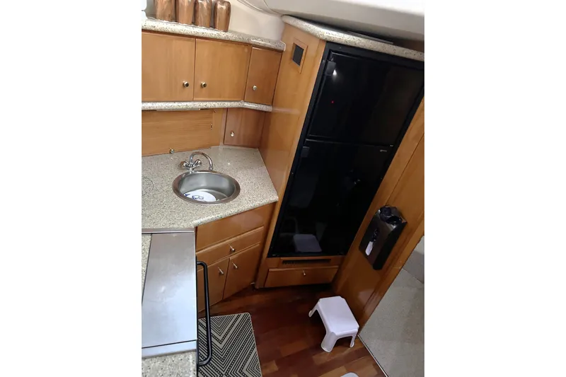  Yacht Photos Pics 2001 Carver 356 Motor Yacht kitchen with sink, cabinets, and black refrigerator.