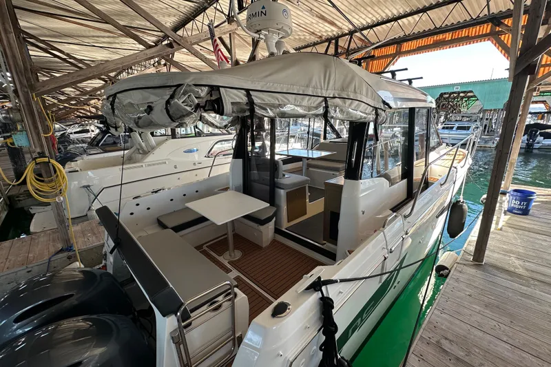 Mauka Makai Yacht Photos Pics 2021 Jeanneau NC 895 boat docked, featuring a covered seating area and modern design.