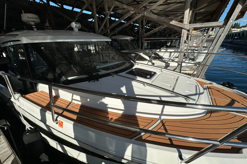 Mauka Makai Yacht Photos Pics 2021 Jeanneau NC 895 boat docked under a wooden shelter.