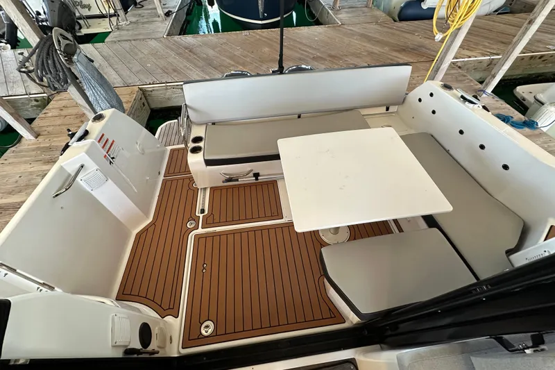 Mauka Makai Yacht Photos Pics 2021 Jeanneau NC 895 boat cockpit with seating and table, docked at marina.