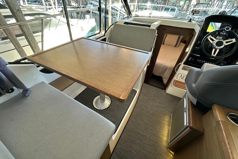 Mauka Makai Yacht Photos Pics Interior of 2021 Jeanneau NC 895 boat with dining area and helm station.