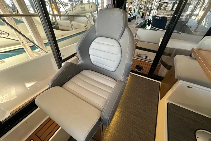 Mauka Makai Yacht Photos Pics Captain's chair inside a 2021 Jeanneau NC 895 boat, featuring sleek design and comfortable seating.
