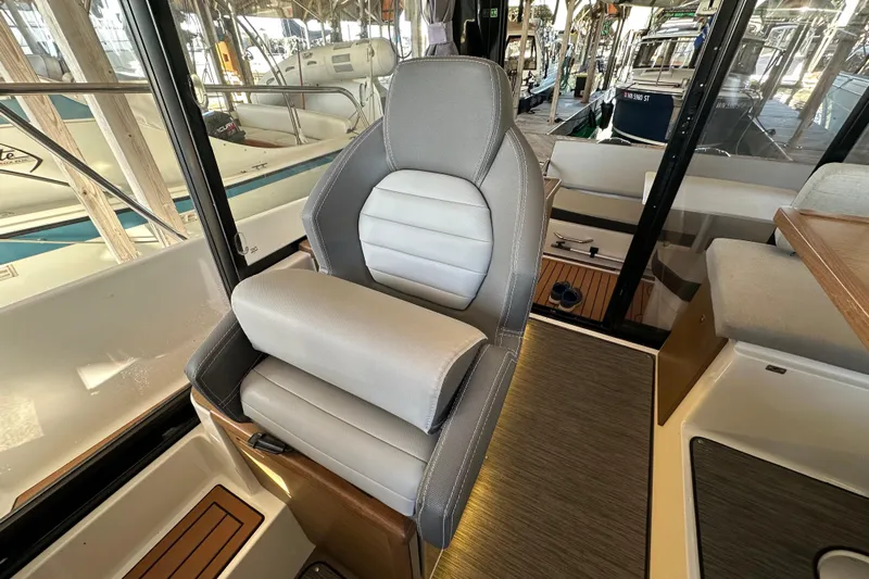 Mauka Makai Yacht Photos Pics Captain's seat in 2021 Jeanneau NC 895 boat interior, showcasing modern design and comfort.