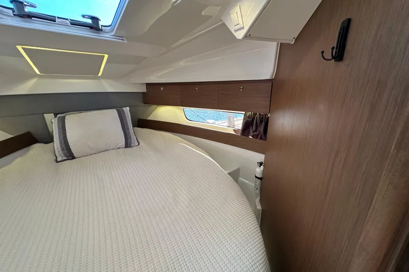 Mauka Makai Yacht Photos Pics Cozy cabin interior of 2021 Jeanneau NC 895 with bed and window view.
