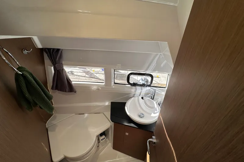 Mauka Makai Yacht Photos Pics 2021 Jeanneau NC 895 bathroom interior with sink, toilet, and window.