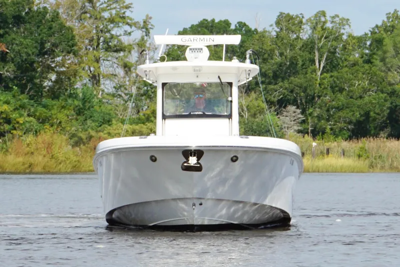  Yacht Photos Pics 2012 Everglades 325 Center Console boat on water, surrounded by lush greenery.