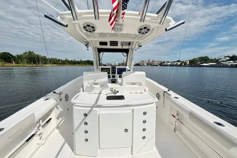  Yacht Photos Pics 2012 Everglades 325 Center Console boat on calm water, featuring a spacious deck and control panel.