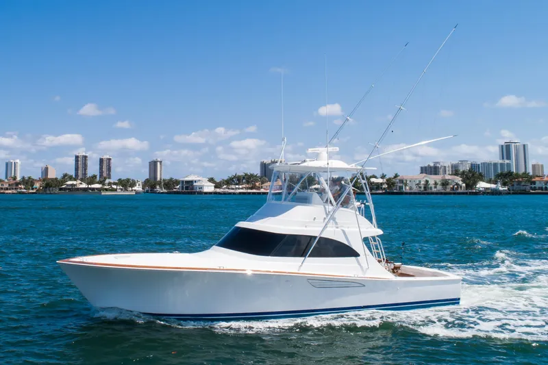 Can Do Yacht Photos Pics 2023 Viking 46 Billfish yacht cruising on blue water near city skyline.