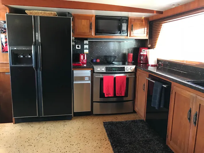  Yacht Photos Pics Kitchen interior of 1977 Monk McQueen 72 CPMY yacht with modern appliances and wooden cabinetry.