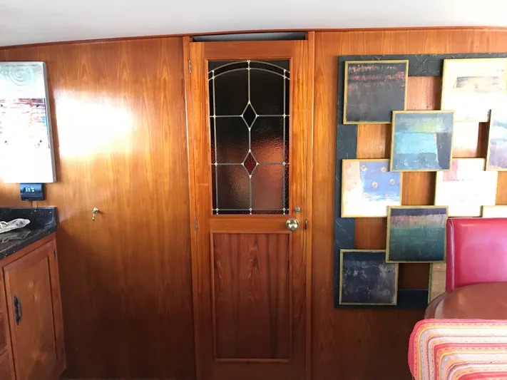 Yacht Photos Pics Interior of 1977 Monk McQueen 72 CPMY with wooden door and decorative wall art.