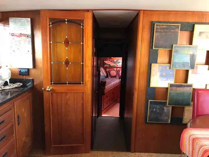  Yacht Photos Pics Interior of 1977 Monk McQueen 72 CPMY yacht with wooden door and decorative wall art.