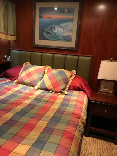  Yacht Photos Pics Cozy cabin interior of 1977 Monk McQueen 72 CPMY with colorful bedding and fish artwork.