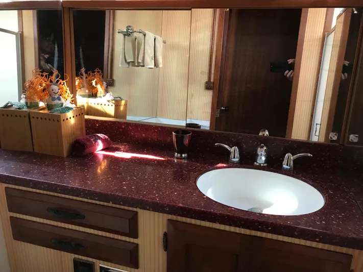  Yacht Photos Pics 1977 Monk McQueen 72 CPMY bathroom with red countertop, sink, and decorative elements.