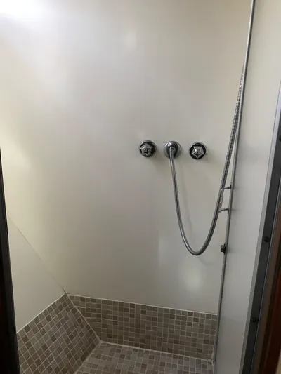  Yacht Photos Pics Shower area in 1977 Monk McQueen 72 CPMY yacht with tiled floor and chrome fixtures.