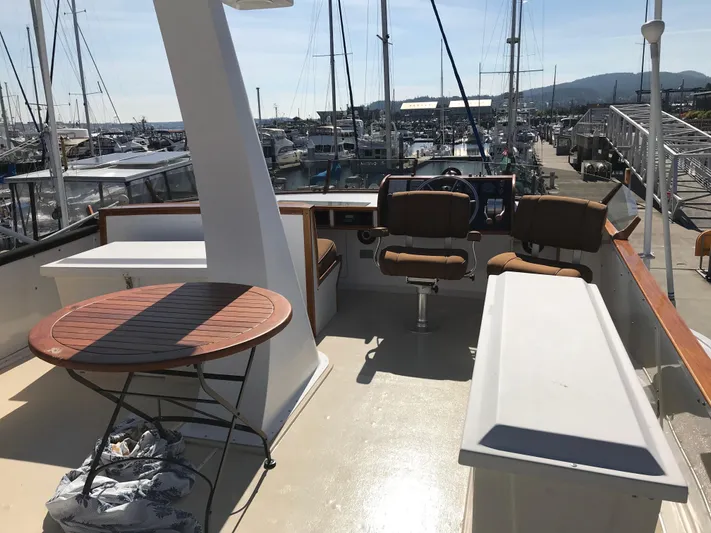  Yacht Photos Pics 1977 Monk McQueen 72 CPMY yacht deck with seating and table, docked at marina.