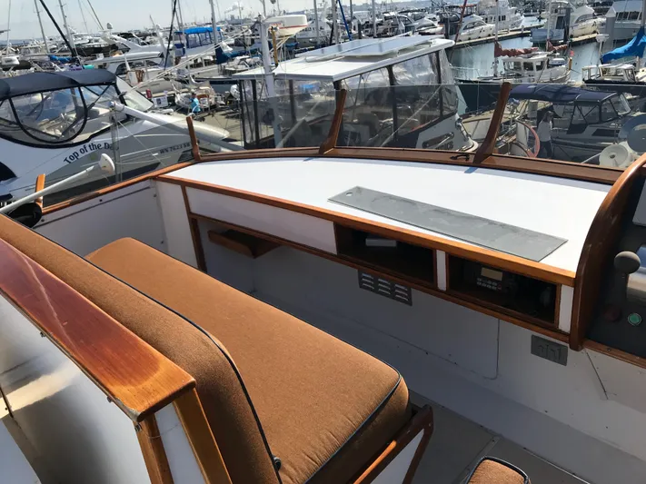  Yacht Photos Pics 1977 Monk McQueen 72 CPMY yacht helm with wooden accents and marina view.